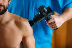 Massage gun in use, providing a soothing deep tissue massage to a person’s shoulder for muscle relaxation